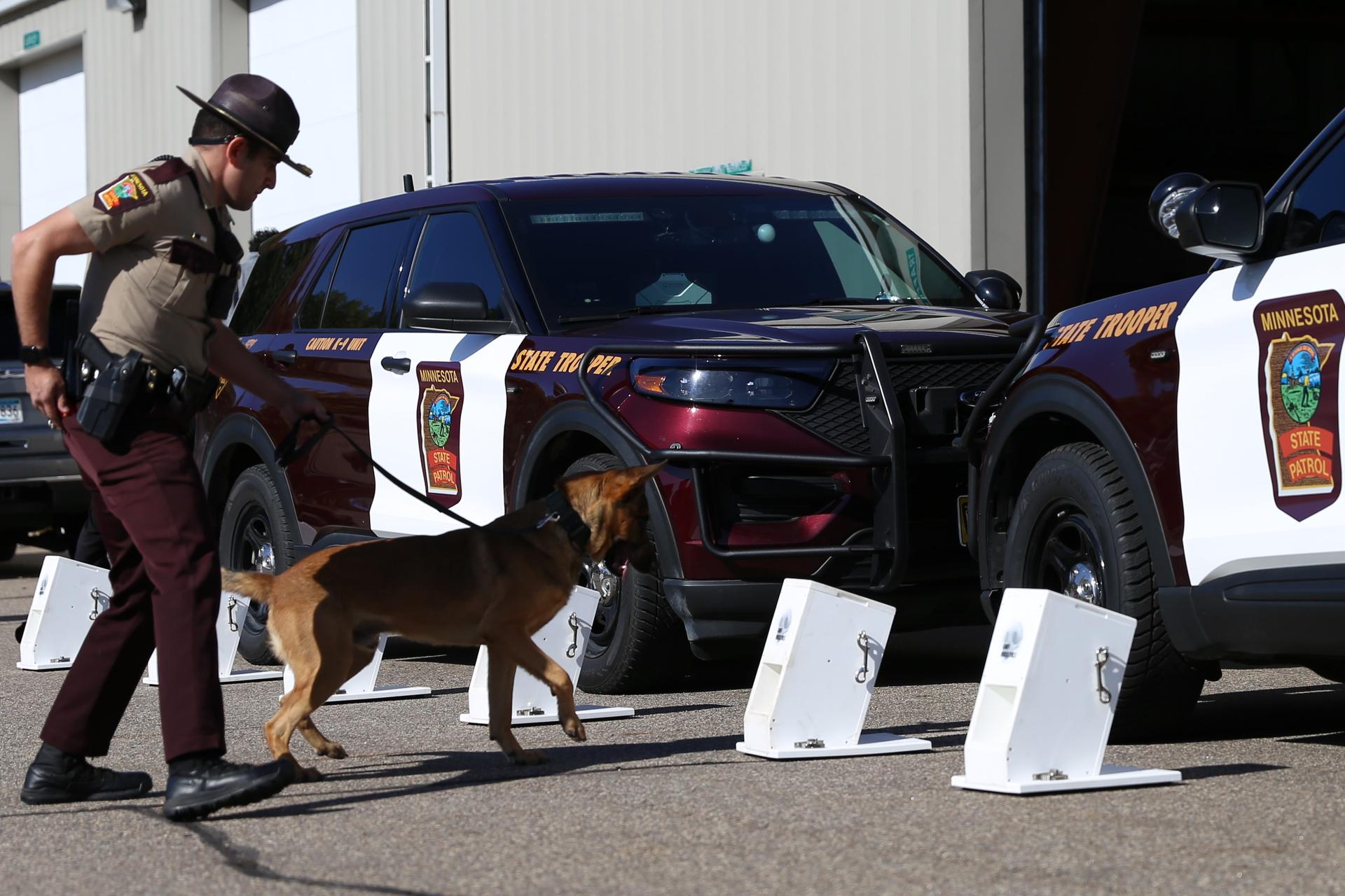 Trooper holding leash with K-9